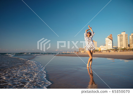 Charming woman posing on the beach 65850070