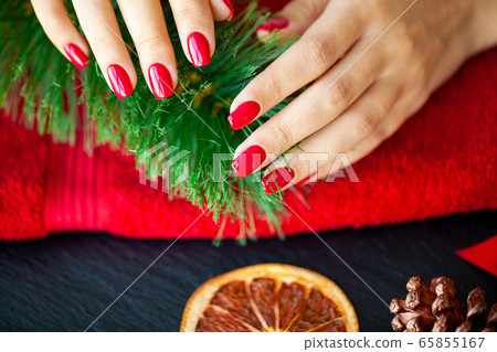 Red Christmas manicure make in beauty studio on Christmas background 65855167