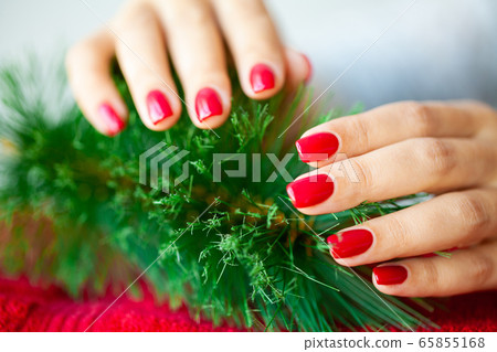 Red Christmas manicure make in beauty studio on Christmas background Red Christmas manicure make in beauty studio on Christmas background 65855168