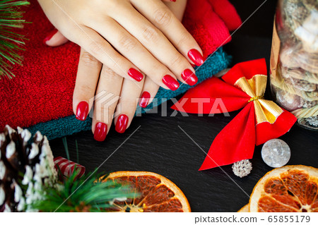 Red Christmas manicure make in beauty studio on Christmas background 65855179
