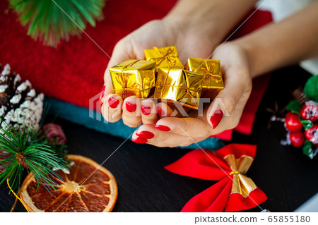 Red Christmas manicure make in beauty studio on Christmas background Red Christmas manicure make in beauty studio on Christmas background 65855180