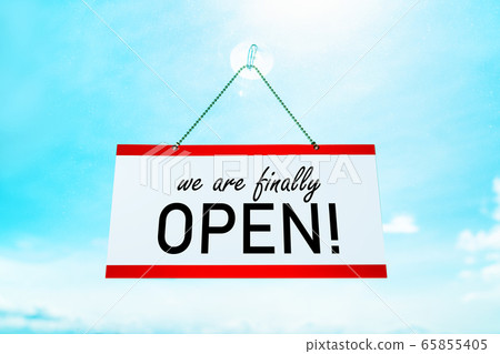 COVID-19 WE'RE FINALLY OPEN ! sign hanging on window store end of confinement stores reopening . Retail businesses opening again for non essential services. Sunny summer background 65855405