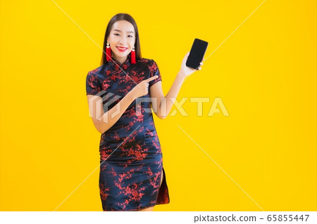 Portrait beautiful young asian woman wear chinese dress use smart mobile phone 65855447