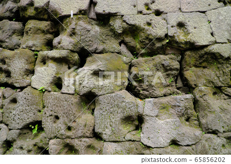 Innumerable bullet holes in the stone wall 65856202