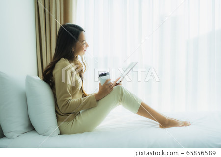 Young asian woman with coffee cup and read book Young asian woman with coffee cup and read book 65856589