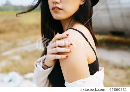 Thai woman touching her shoulder. 65860381
