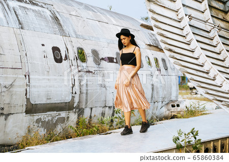 Beautiful thai woman walking on airplane wreck. Beautiful thai woman walking on airplane wreck. 65860384