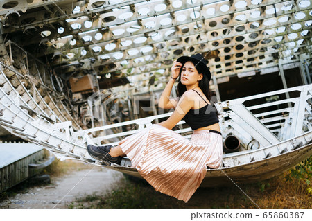 Beautiful thai woman sitting on a plane wreck. Beautiful thai woman sitting on a plane wreck. 65860387
