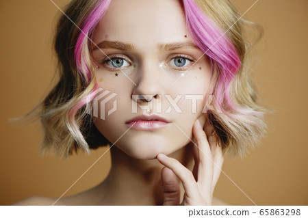 Woman with golden glitter stars on her face. Woman with golden glitter stars on her face. 65863298