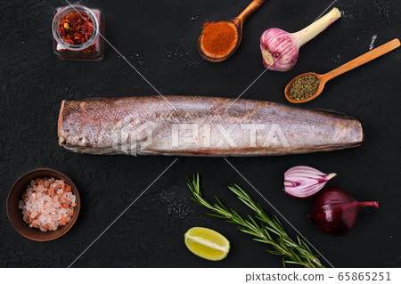 Hake with spice on black background Hake with spice on black background 65865251