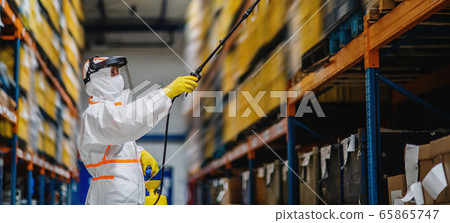 Man worker with protective mask and suit disinfecting industrial factory with spray gun. 65865747