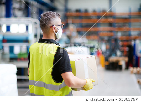 Man worker with protective mask working in industrial factory or warehouse. Man worker with protective mask working in industrial factory or warehouse. 65865767