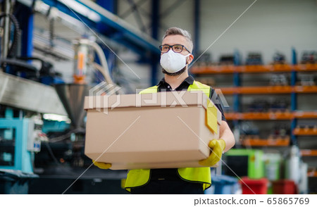 Man worker with protective mask working in industrial factory or warehouse. 65865769
