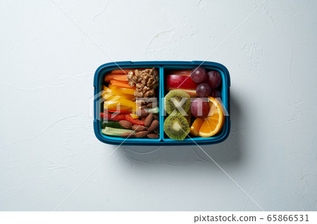 Top View of Full Lunch Box with Fuits, Vegetables and nuts. Top View of Full Lunch Box with Fuits, Vegetables and nuts. 65866531