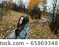 Red-headed freckled girl in autumn yellow park. The first snow, wet rain. 65869348