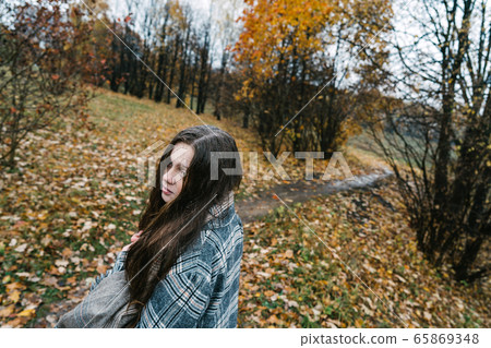 Red-headed freckled girl in autumn yellow park. The first snow, wet rain. Red-headed freckled girl in autumn yellow park. The first snow, wet rain. 65869348