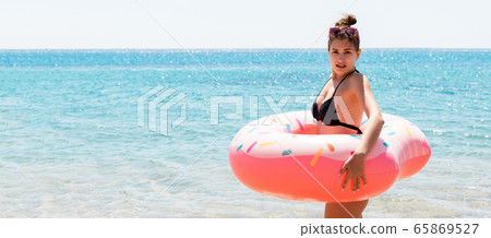 Shocked young woman inside donut rubber ring is Shocked young woman inside donut rubber ring is 65869527