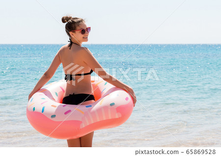 Fit woman with donut inflatable ring is walking 65869528