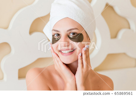Smiling woman wrapped in towel after bath and with 65869561