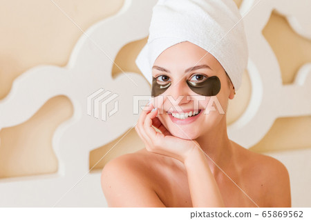Smiling woman wrapped in towel after bath and with 65869562