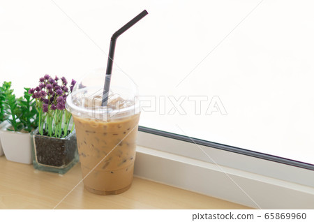 Closeup glass of ice coffee with flower pot in the Closeup glass of ice coffee with flower pot in the 65869960