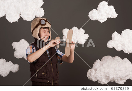a boy plays with a cardboard airplane and dreams a boy plays with a cardboard airplane and dreams 65870829