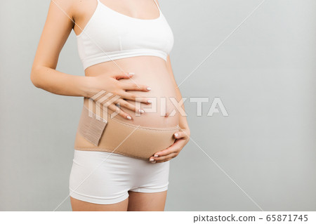 Close up of pregnant woman in underwear using Close up of pregnant woman in underwear using 65871745