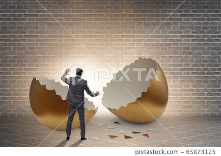 Businessman breaking out of golden egg 65873125