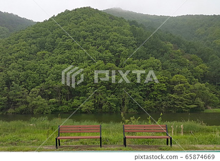 Empty chairs riverside bench 65874669