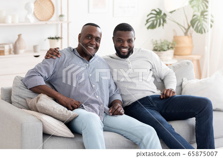 Portrait Of Senior African Man Posing At Home With His Adult Son Portrait Of Senior African Man Posing At Home With His Adult Son 65875007