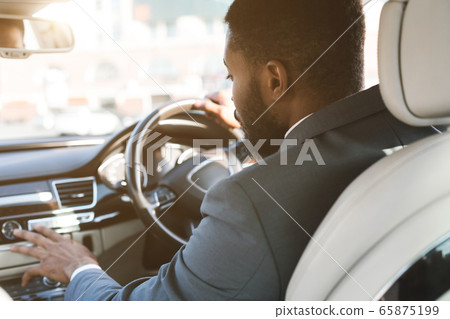 Unrecognizable Driver Man Pushing Buttons Driving Car, Rear View Unrecognizable Driver Man Pushing Buttons Driving Car, Rear View 65875199