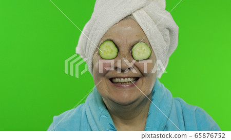 Elderly grandmother in bathrobe after shower. Old woman with slices of cucumber 65876752