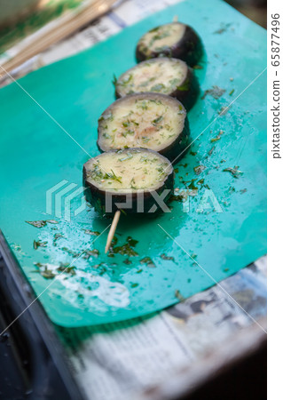 in a bowl, raw, struck eggplant in a marinade with herbs, dill in a rustic natural form. Preparation 65877496