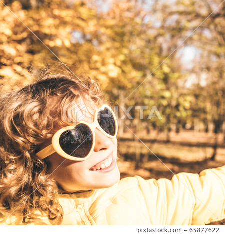 Happy child having fun outdoor in autumn park 65877622