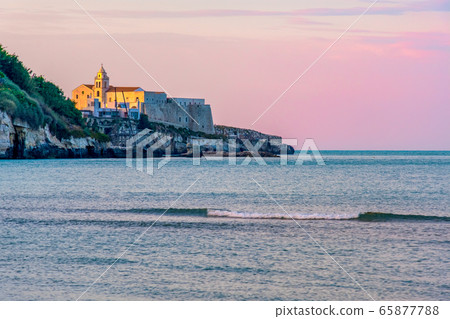 south italy background of Vieste church village at sunset by the sea with purple sky south italy background of Vieste church village at sunset by the sea with purple sky 65877788