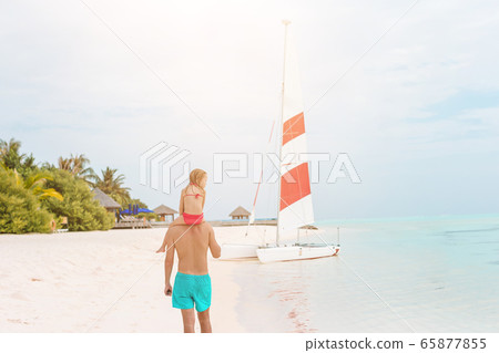 Little girl and happy dad having fun during beach vacation Little girl and happy dad having fun during beach vacation 65877855