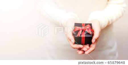 Close up shot of daughter hands holding a small gift Close up shot of daughter hands holding a small gift 65879648