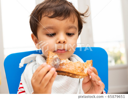 Toddler eating a toast Toddler eating a toast 65879651