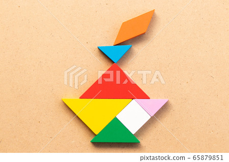 Color tangram puzzle in candle shape on wood background 65879851