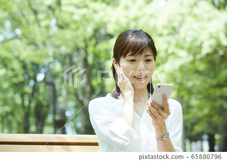 A woman watching a smartphone A woman watching a smartphone 65880796