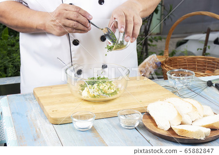 Chef putting minced parsley to bowl for cook Chef putting minced parsley to bowl for cook 65882847