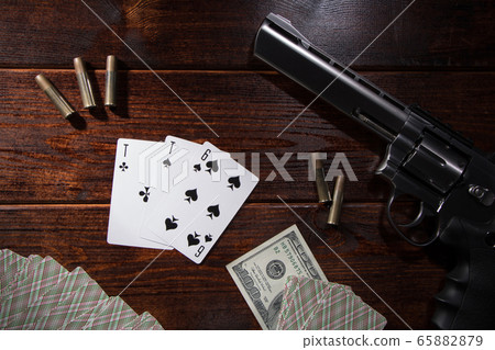 Money games and gambling card games.The gun, playing cards and ammunition are on the table.Criminal gambling in nightclubs and casinos.Hazardous night of entertainment in criminal cases for the mafia 65882879
