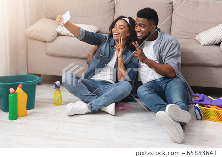 Happy Black Couple Taking Selfie On Smartphone After Tidying Flat 65883641