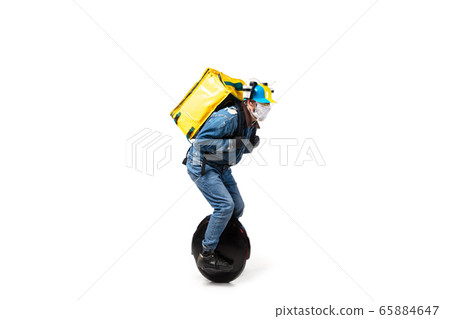 Too much orders. Contacless delivery service during quarantine. Man delivers food and shopping bags during isolation, wearing gloves and face mask. 65884647