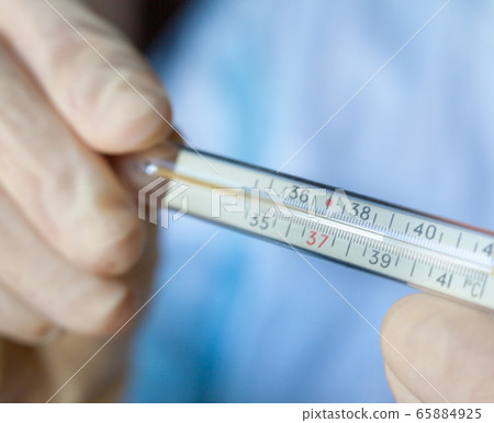 Hands holding medical thermometer. Hands holding medical thermometer. 65884925