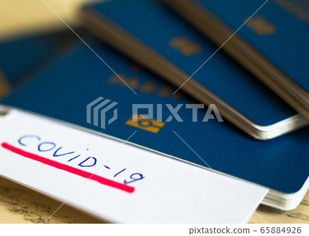 Passport and note with Covid-19 inscription. Passport and note with Covid-19 inscription. 65884926