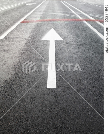 White arrow on the road. 65884943