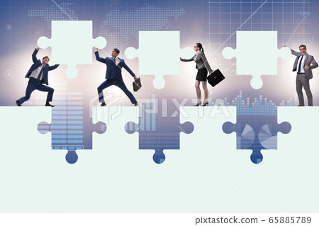 Businessman in teamwork concept with jigsaw puzzle 65885789