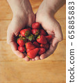 A handful of red, fresh strawberries in male hands 65885883