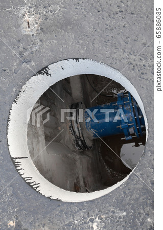 Open manhole in the concrete block Open manhole in the concrete block 65886085